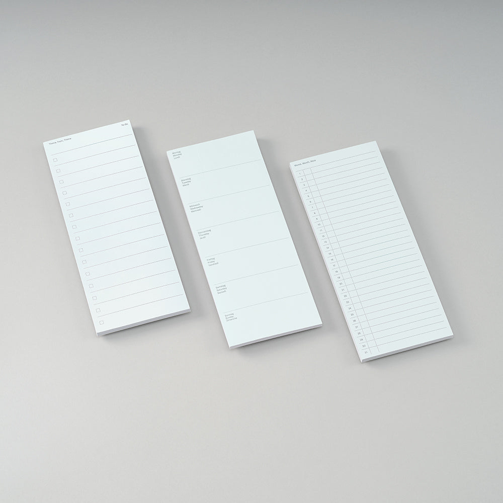 Three white lined notepad sheets arranged diagonally on a light gray background.